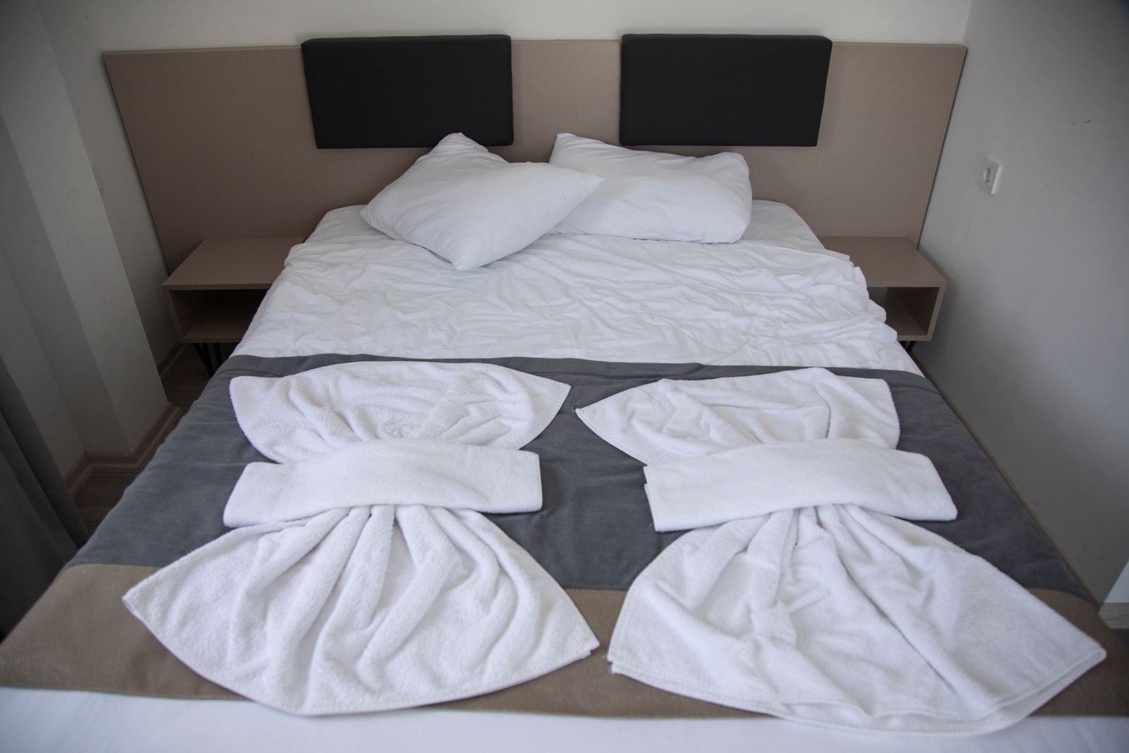 Hotel-style guest bedroom with fresh white linen and towels